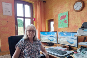 Porträt von Gabriele Strube an ihrem Arbeitsplatz mit zwei Monitoren in der VLH-Beratungsstelle.