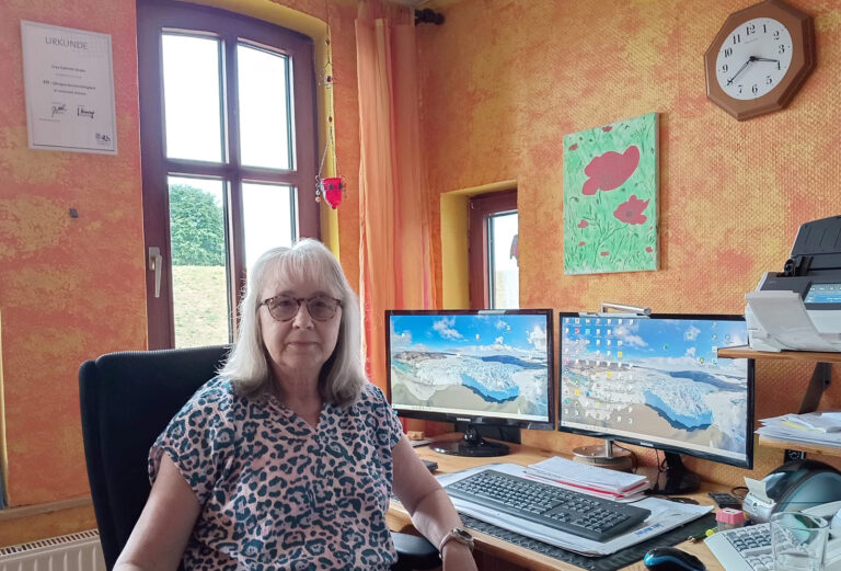 Porträt von Gabriele Strube an ihrem Arbeitsplatz mit zwei Monitoren in der VLH-Beratungsstelle.