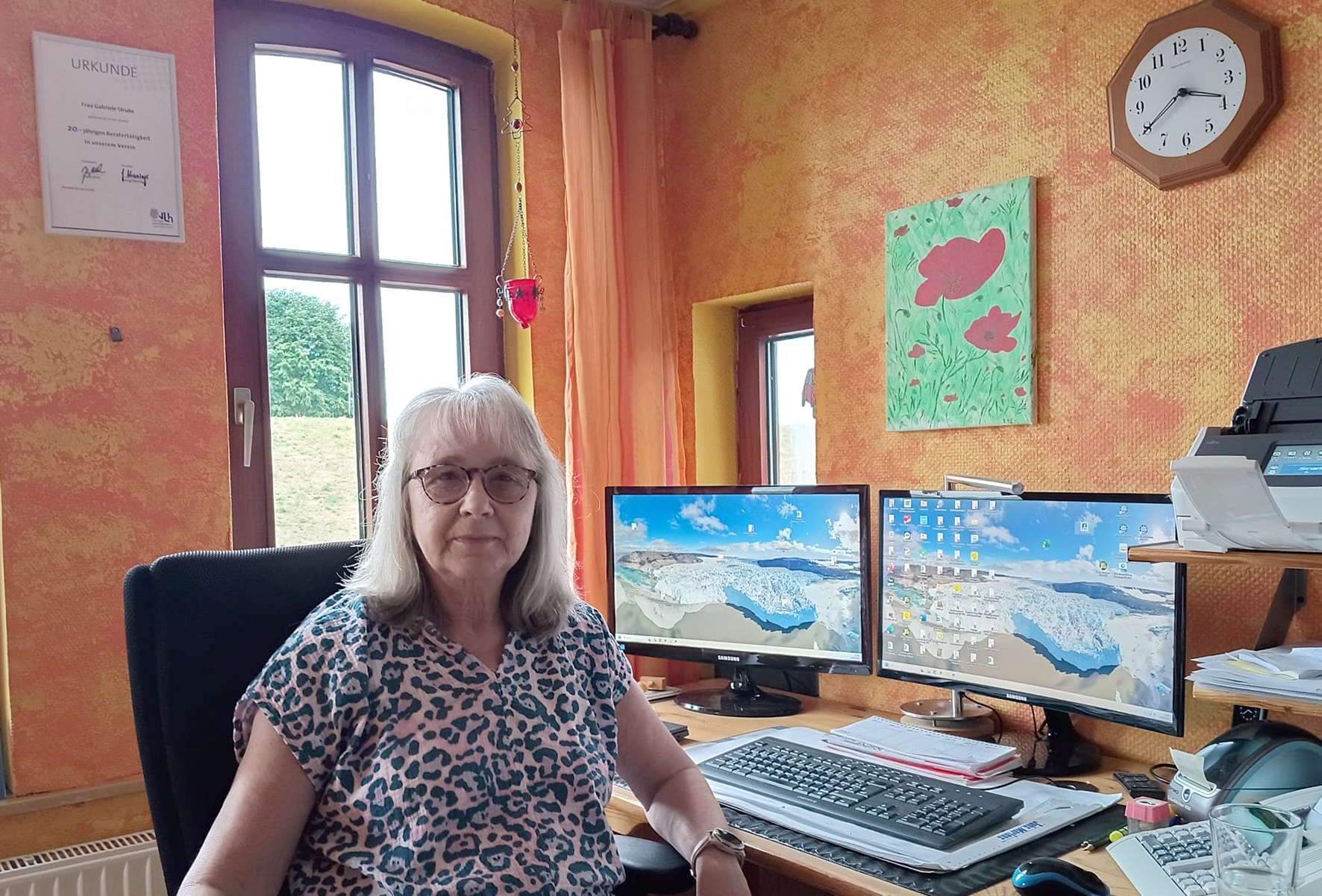 Porträt von Gabriele Strube an ihrem Arbeitsplatz mit zwei Monitoren in der VLH-Beratungsstelle.
